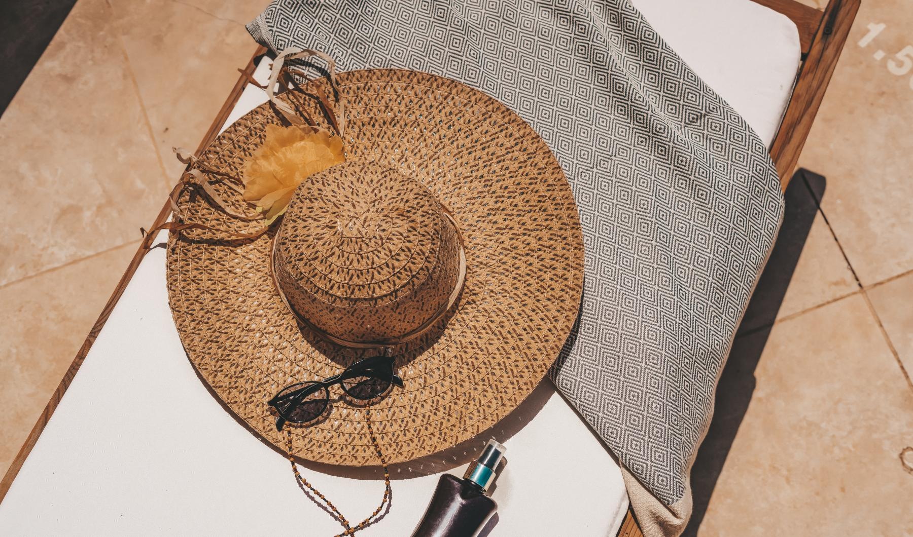 a hat and glasses on a lounge chair